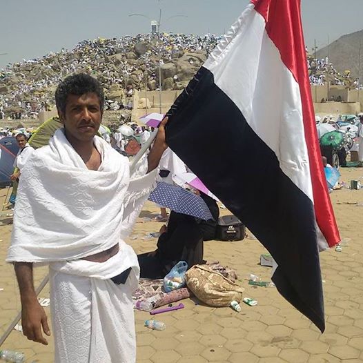 يمني يرفع علم بلاده أثناء تأديته مناسك الحج