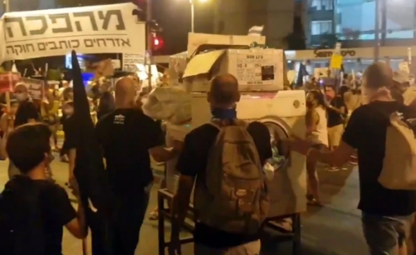 بعد فضيحة ملابسه المتسخة.. إسرائيليون يحضرون غسالة في مظاهراتهم ضد نتنياهو